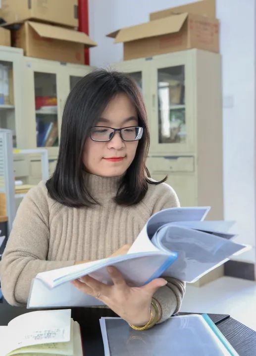 A person wearing glasses and headphones reading a book Description automatically generated with low confidence