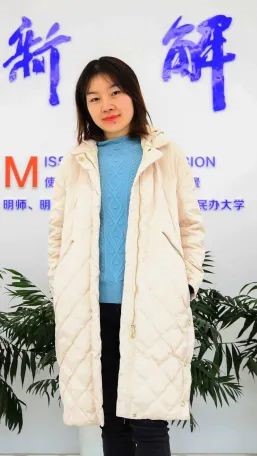 A person standing in front of a wall with writing on it Description automatically generated with medium confidence